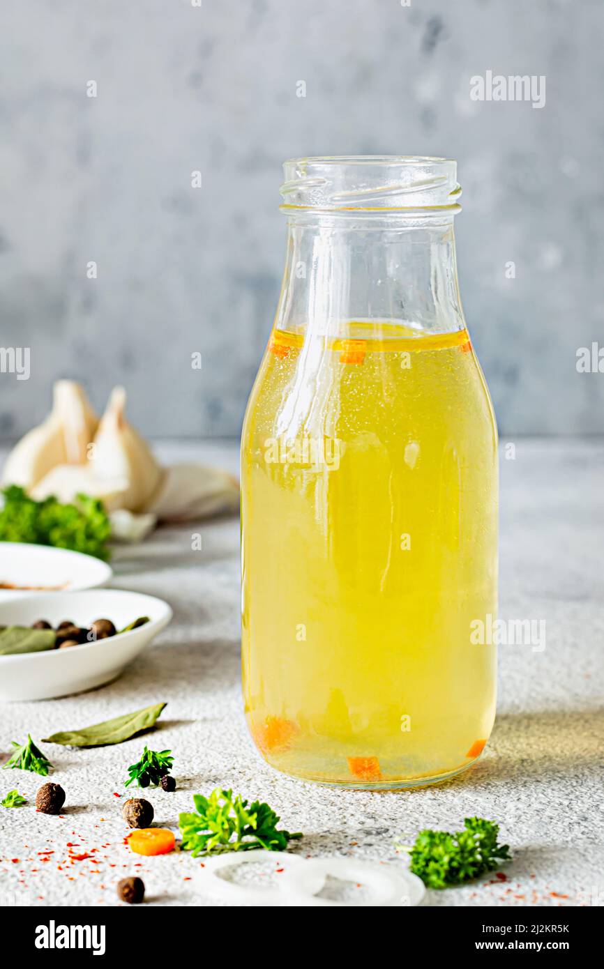 Homemade chicken (bone) broth (bouillon) with vegetables, spices and