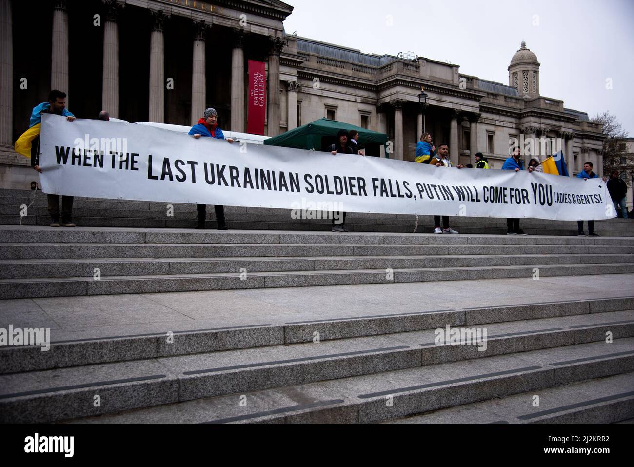 London, UK. 02nd Apr, 2022. Protestors hold a large banner on the stairs during the demonstration at Trafalgar Square. Protests continued in London's Trafalgar Square in solidarity with the people of Ukraine, as war continues to rage due to the Russian invasion. Credit: SOPA Images Limited/Alamy Live News Stock Photo