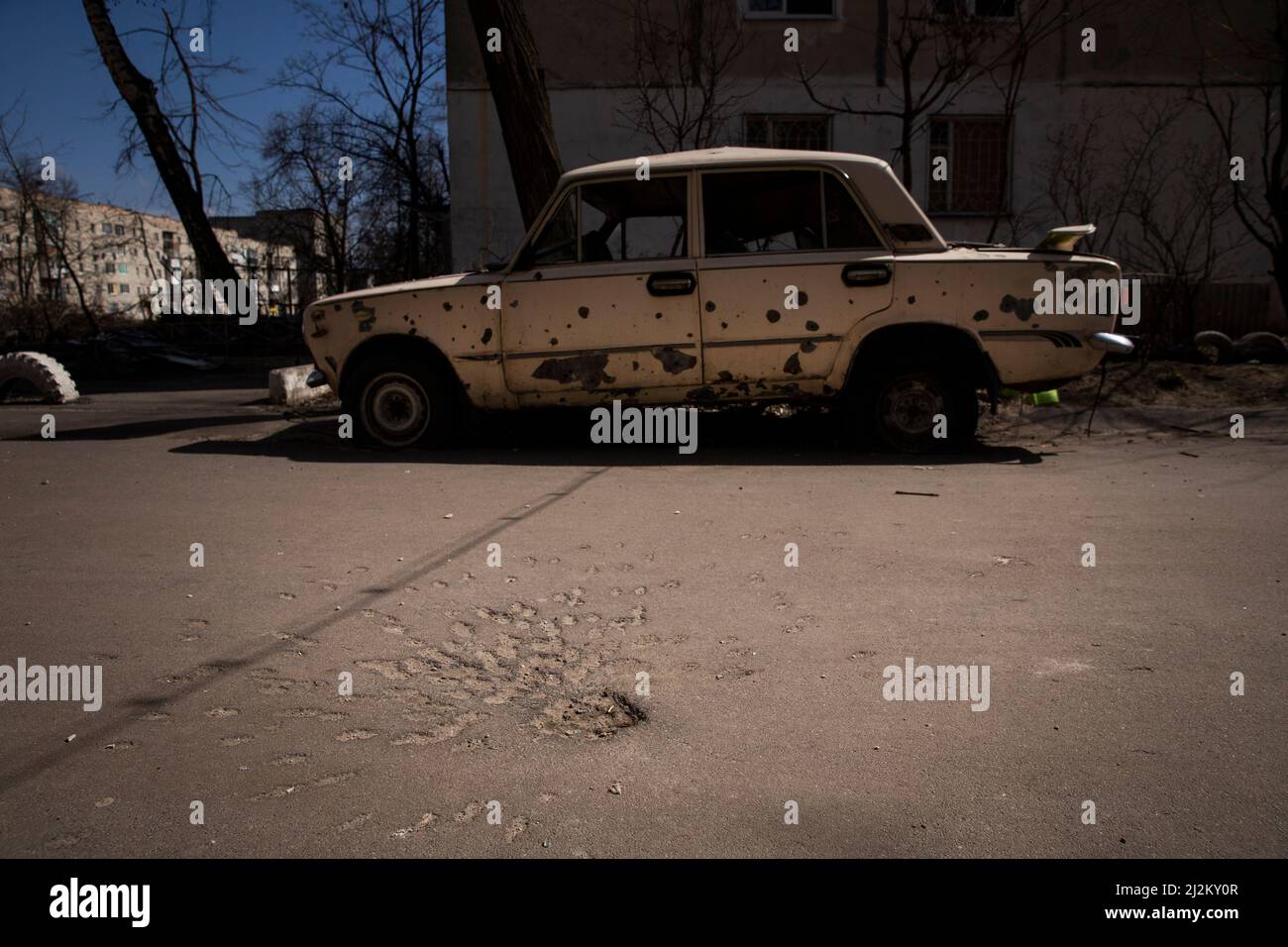 Okhtyrka, Sumy, Ukraine. 2nd Apr, 2022. A car is damaged by shrapnel after a Russian shell landed nearby at Okhtyrka, Ukraine on April 2, 2022. The asphalt below the car shows where the shell landed (Credit Image: © Daniel Carde/ZUMA Press Wire) Credit: ZUMA Press, Inc./Alamy Live News Stock Photo
