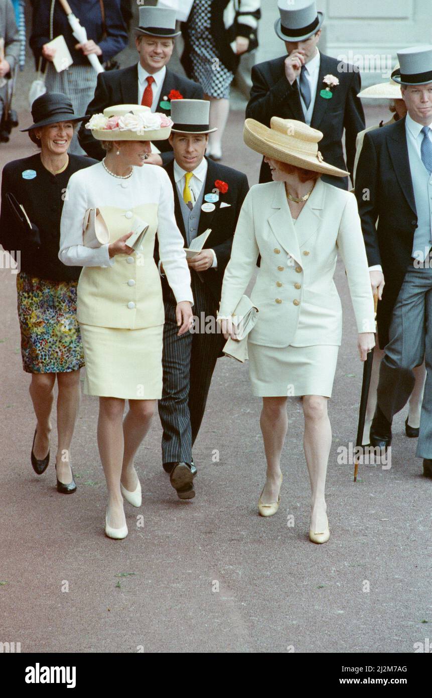 HRH The Princess of Wales, Princess Diana, (left) and The Duchess of York (right)  enjoy the day as they walk along talking to each other at the Royal Ascot event of June 1991. Princess Diana wears a lemon and white silk suit designed by Catherine Walker.  And a rose-filled brim hat. Designer not known of this.  Picture taken 19th  June 1991 Stock Photo