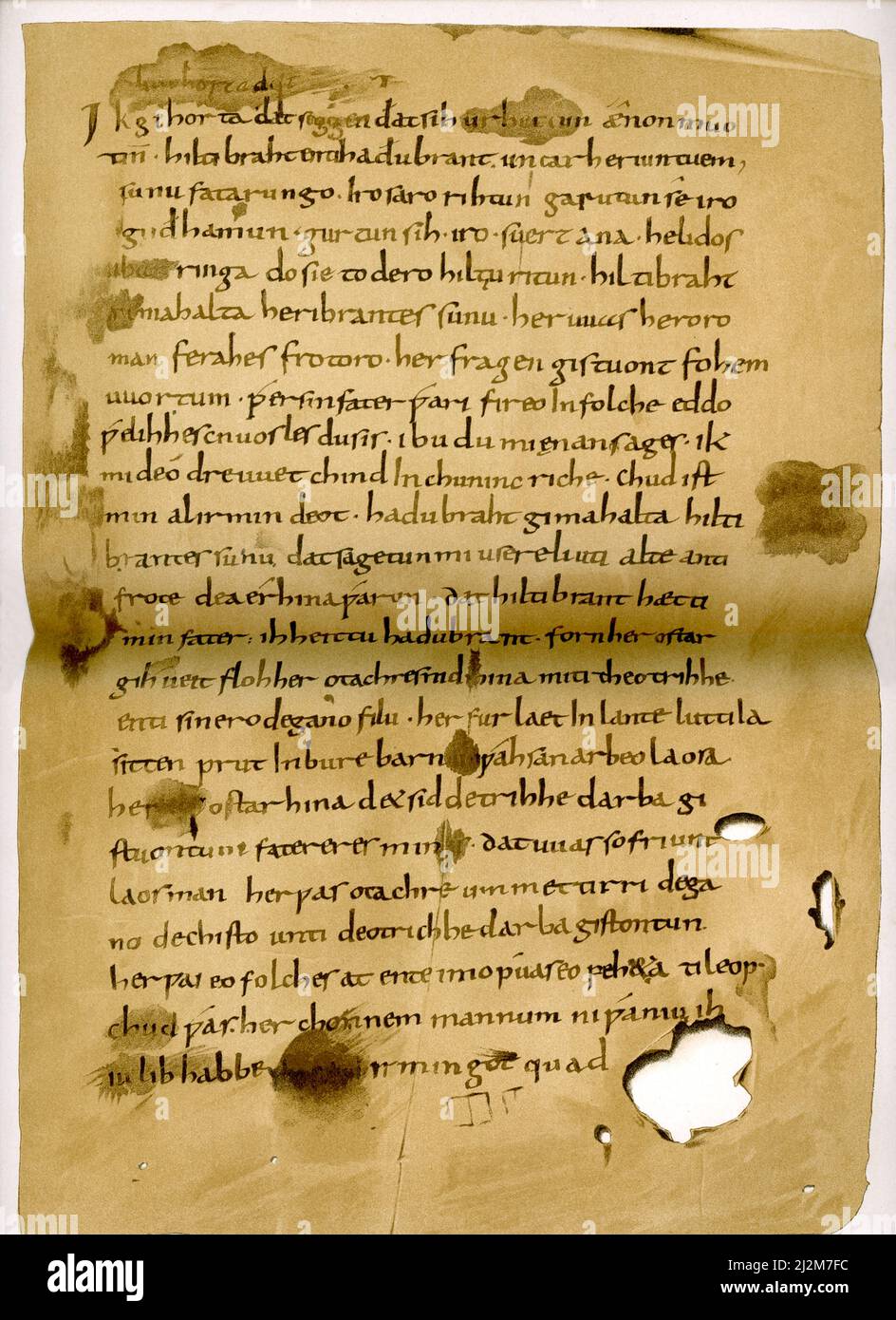 The  English translation of the German caption reads: “Hildebrandslied from the handwritten manuscript dating to 8th-9th century. [Housed} in in the Landesbibliothek [Library] in Kassel [Germany].” The Hildebrandslied (Song of Hildebrand)) is the earliest poetic text in German. It tells of the tragic encounter in battle between a father (Hildebrand) and a son (Hadubrand) who does not recognize him. The text was written in the 830s on two spare leaves on the outside of a religious codex in the monastery of Fulda. The story is set against the background of the historical conflict between Theodor Stock Photo
