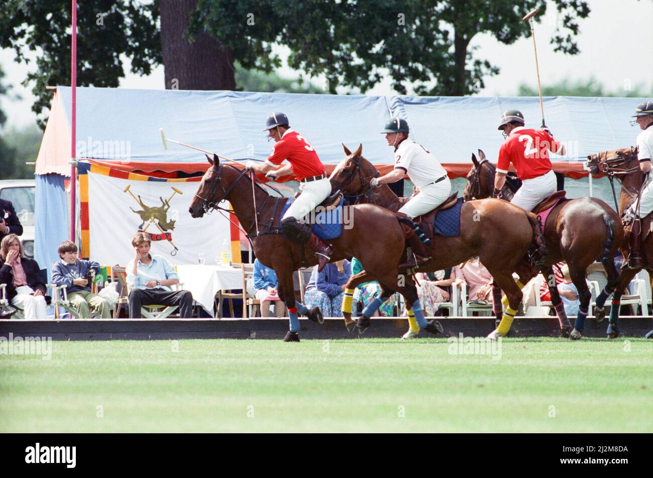 Prince Charles (Red shirt wearing number 3) was locked in a fierce battle with Princess Diana's friend Major James Hewitt  today (white shirt wearing number 2) , on the polo field. At one stage, as Major Hewitt challenged the prince, the commentator exclaimed 'Oh, I say ! That riding off was a bit  rough'  Despite determined riding by Charles, the Gulf hero's team won 4-1 at Windsor.  The polo prizes were presented by another royal, Princess Beatrice, the two year old daughter of The Duchess of York and Prince Andrew.  Picture taken 16th July 1991 Stock Photo