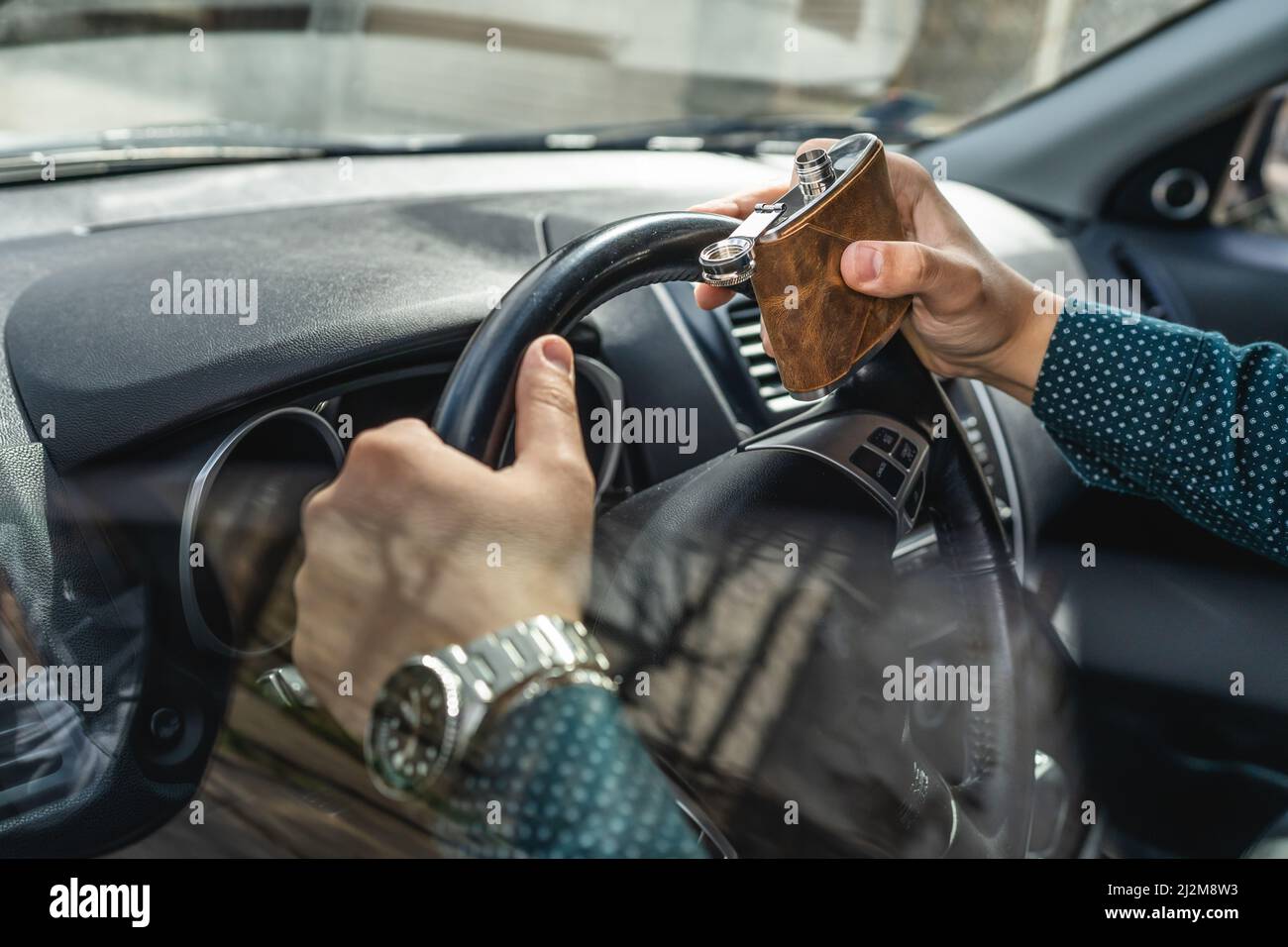 caucasian male drinking alcohol from flask while drive a car drunk close up on drink alcoholism and alcohol abuse concept intoxicated dangerous driver Stock Photo