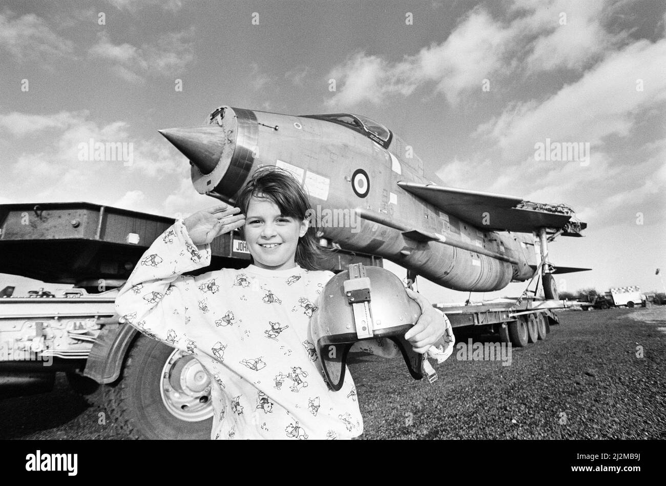 Eight year old Cheryl James poses beside a T55 Lightning fighter jet, the latest arrival at the Midland Air Museum at Coventry Airport, Baginton. The former Royal Saudi Air Force jet was transported from British Aerospace's aerodrome in Warton, Lancashire under police escort. 14th January 1989. Stock Photo