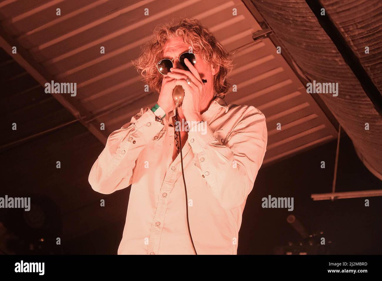 Nick Reynolds, aka Harpo Strangelove harmonica player, singer, UK's foremost creator of Death Masks and son of Great Train Robber Bruce Reynolds  with the British acid country band Alabama 3, known as A3 in the United States performing live on stage at the Engine Rooms Southampton. Stock Photo