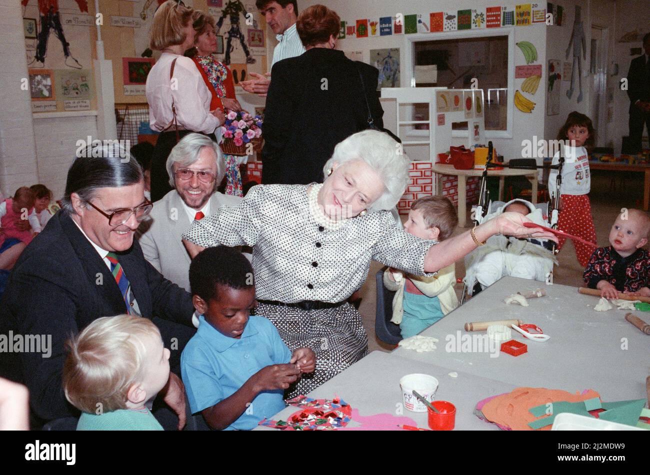 Mrs Barbara Bush, wife of the President of the USA, visits the Strand Adult Education Centre in Brixton. She saw several classes and spoke to staff and students. Pictured, Barbara Bush in the creche, also with Kenneth Baker, Secretary of State for Education and Science. Barbara Bush sings to the children and does actions for 'I'm a little teapot'. 1st June 1989. Stock Photo