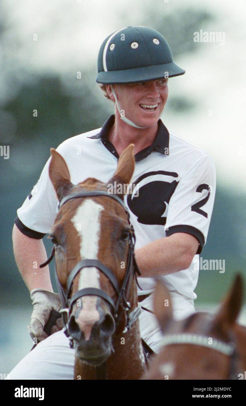 Picture shows Major James Hewitt (wearing white shirt number 2). See other frames in this set which show : Prince Charles (Red shirt wearing number 3) was locked in a fierce battle with Princess Diana's friend Major James Hewitt  today (white shirt wearing number 2) , on the polo field.  At one stage, as Major Hewitt challenged the prince, the commentator exclaimed 'Oh, I say ! That riding off was a bit  rough'  Despite determined riding by Charles, the Gulf hero's team won 4-1 at Windsor.  The polo prizes were presented by another royal, Princess Beatrice, the two year old daughter of The Duc Stock Photo