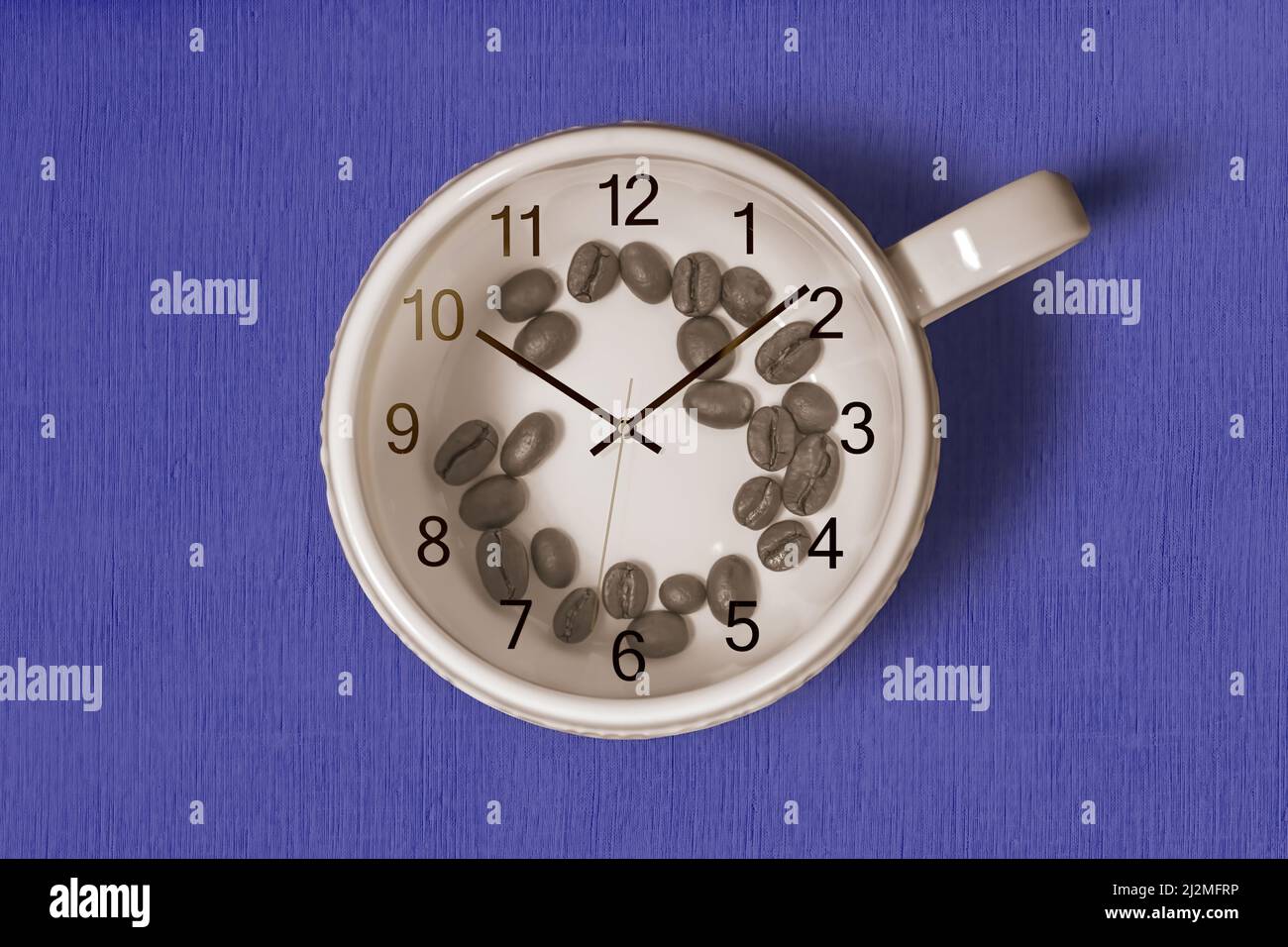 Coffee cup with coffee beans inside and a clock on top of the cup on blue background. Coffee time concept Stock Photo