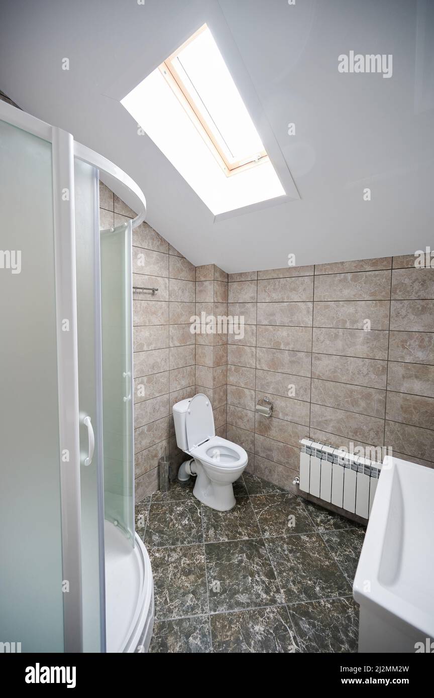 Marble clean washroom with toilet seat and shower space Stock Photo