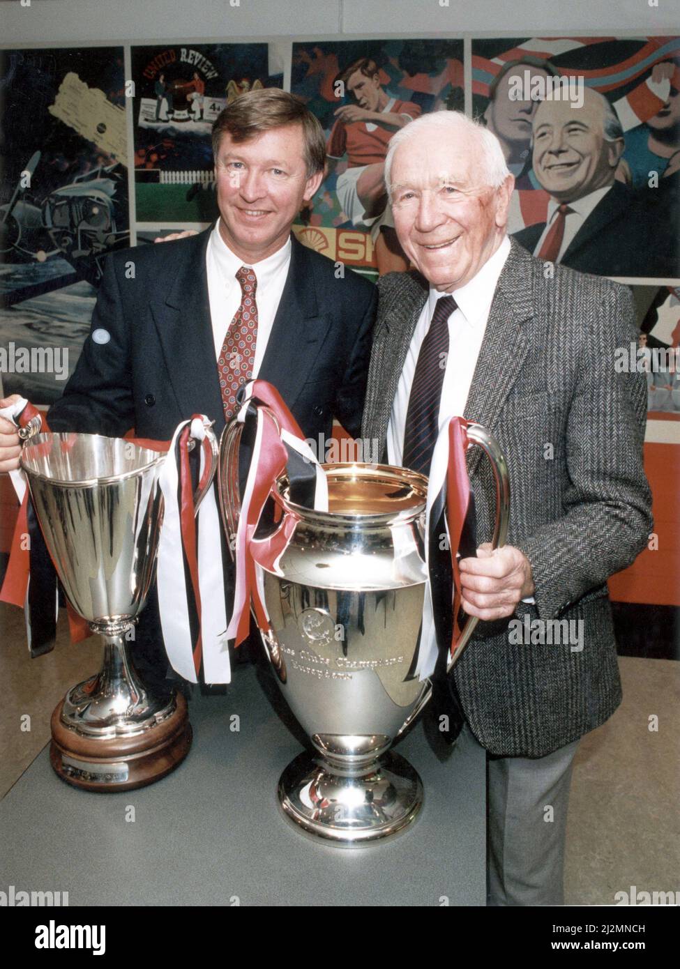 Manchester United manager Alex Ferguson and former manager Sir Matt Busby posing with the European trophies which they ech won as United manager. Ferguson won the Cup Winners Cup following his side's victory over Barcelona in May 1991 and Busby won the European Champions Cup trophy after his side defeated Benfica in the 1968 Final at Wembley. 18th October 1991. Stock Photo