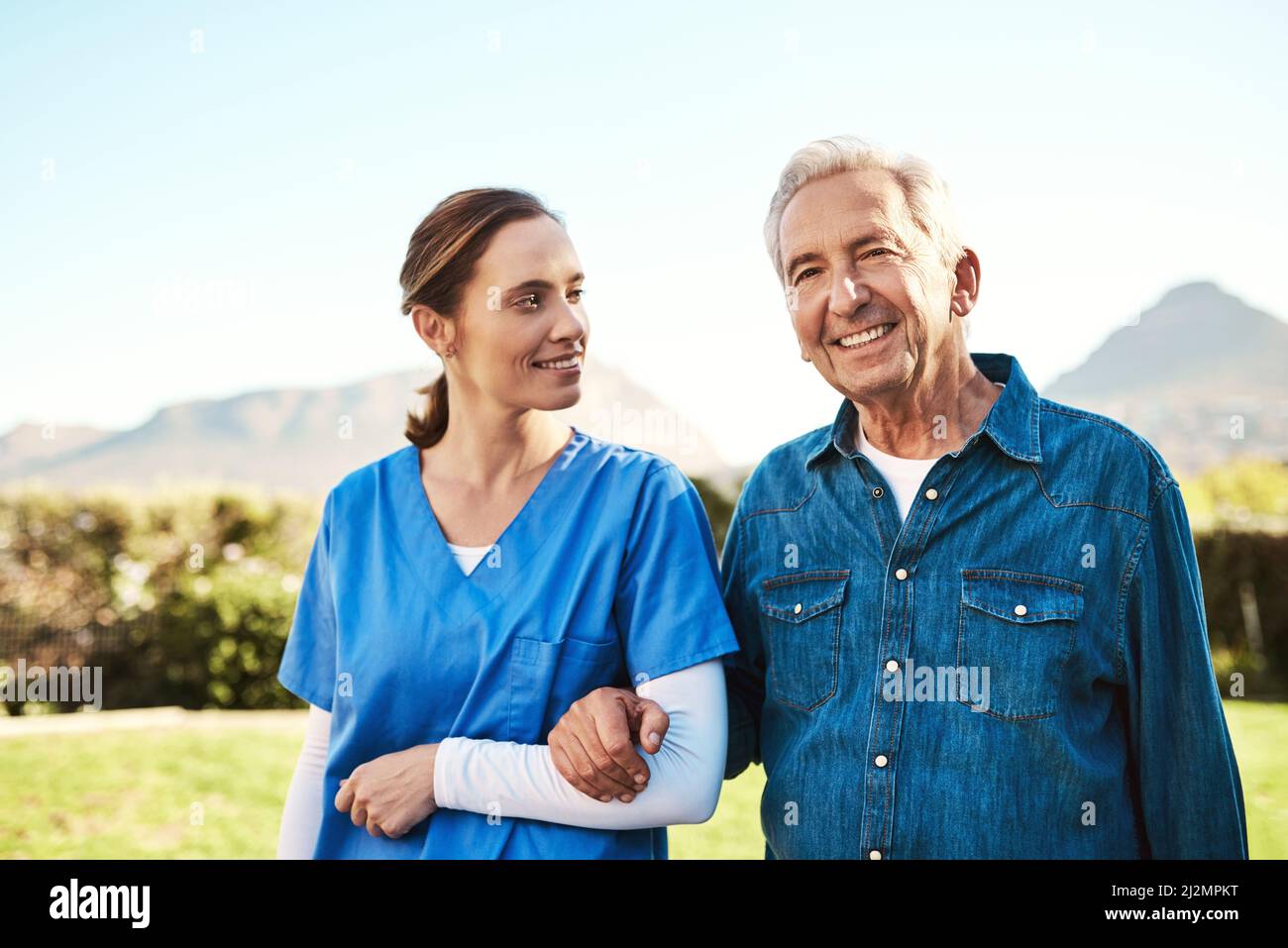 Seeing him happy is my reward. Cropped shot of a young female nurse outside with a senior patient. Stock Photo