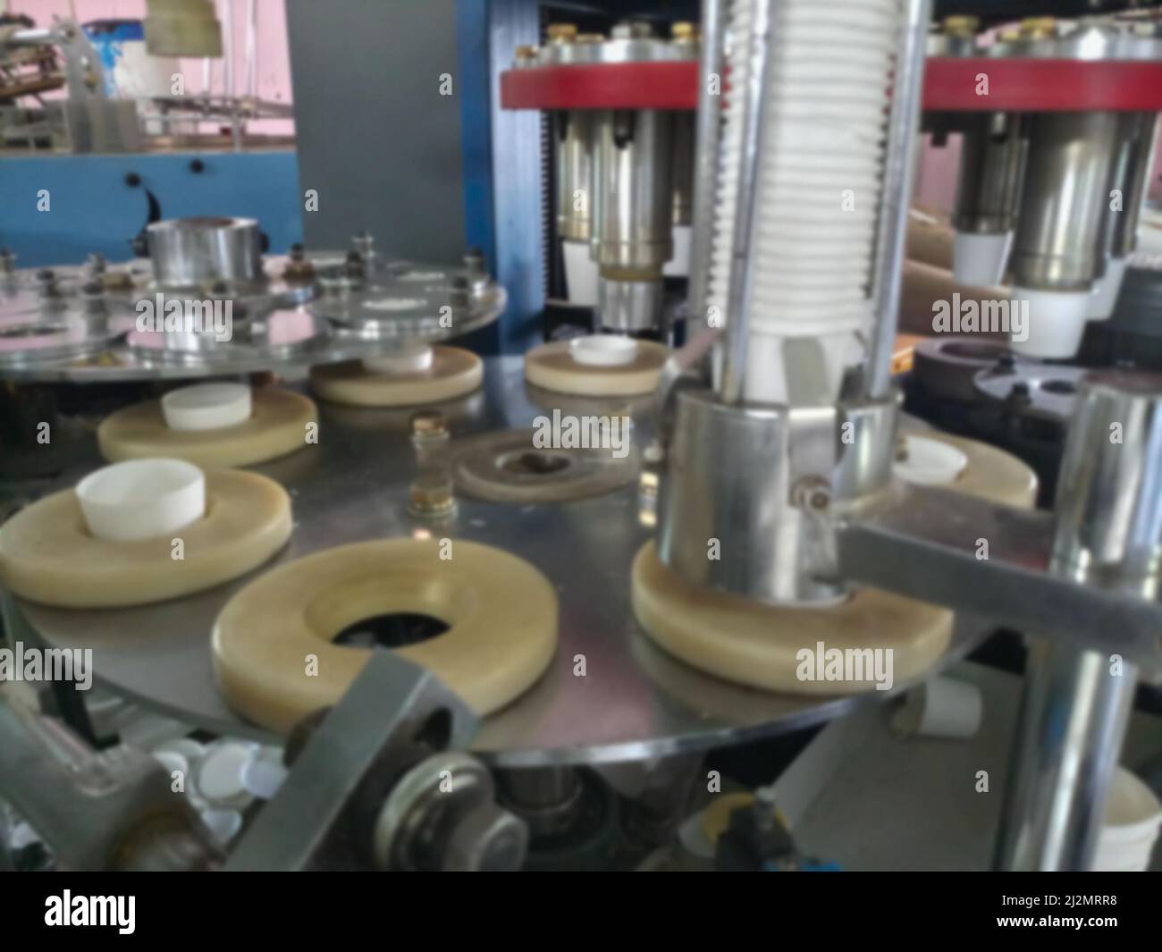 Blurred image of Paper cups are being made from paper, using paper cup manufacturing machines, Inside view of a running cup manufacturing unit. Stock Photo