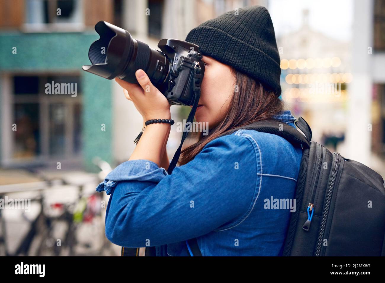 Seeing and capturing the world. Shot of a woman taking pictures with her camera outside. Stock Photo