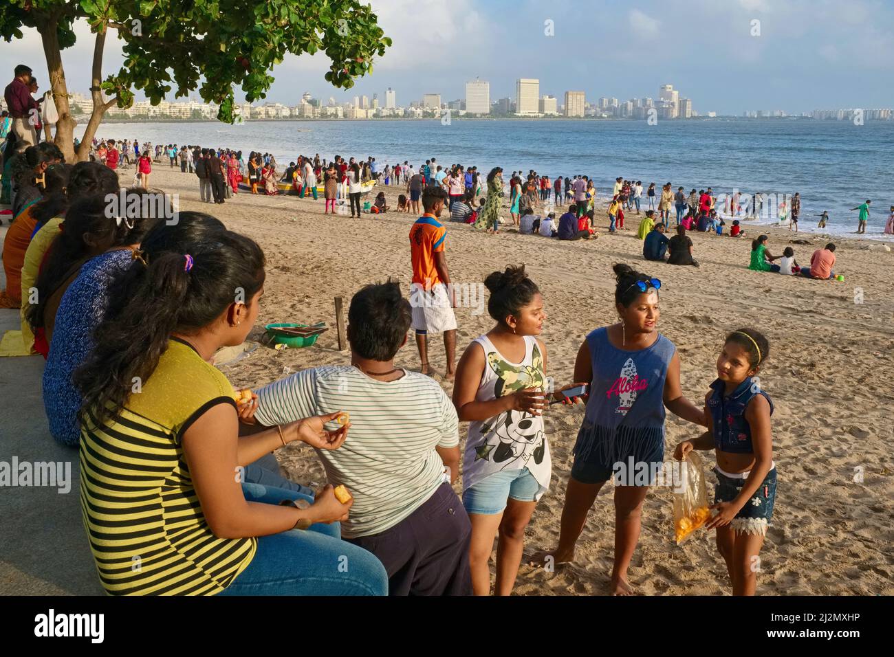 Sightseers throng a stretch of beach near Chowpatty Beach by the Arabian Sea and alongside Marine Drive, Girgaum, Mumbai, India Stock Photo