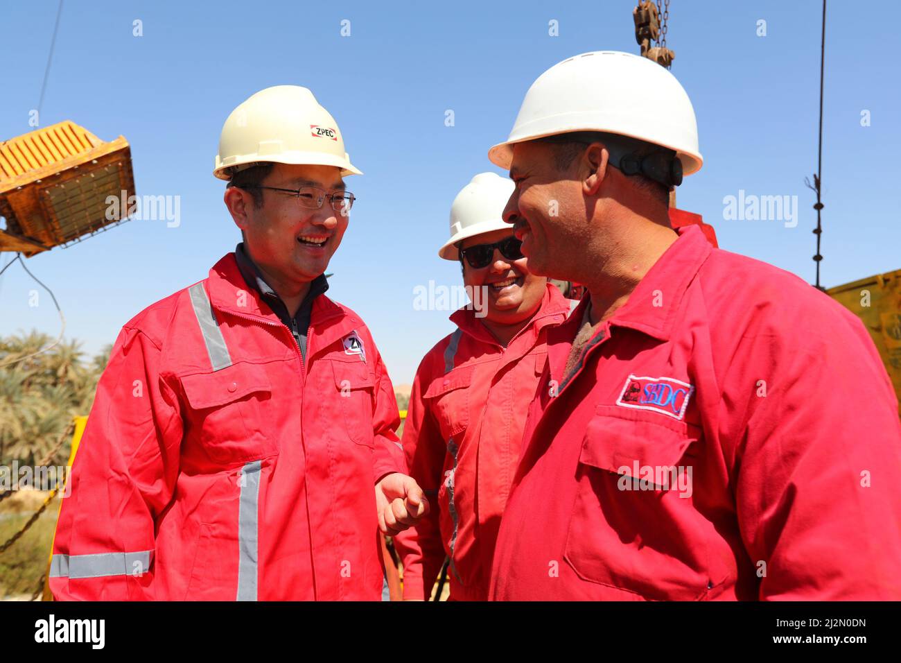 220403 -- SIWA, April 3, 2022 -- Li Wei L, general manager of the ZPEC  branch in Egypt, talks with workers at the drilling site of deepwater wells  dug by the Chinese