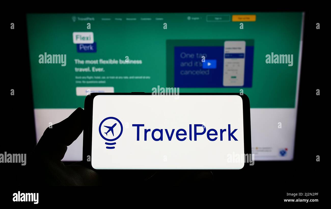 Person holding mobile phone with logo of Spanish software company TravelPerk S.L.U on screen in front of business web page. Focus on phone display. Stock Photo