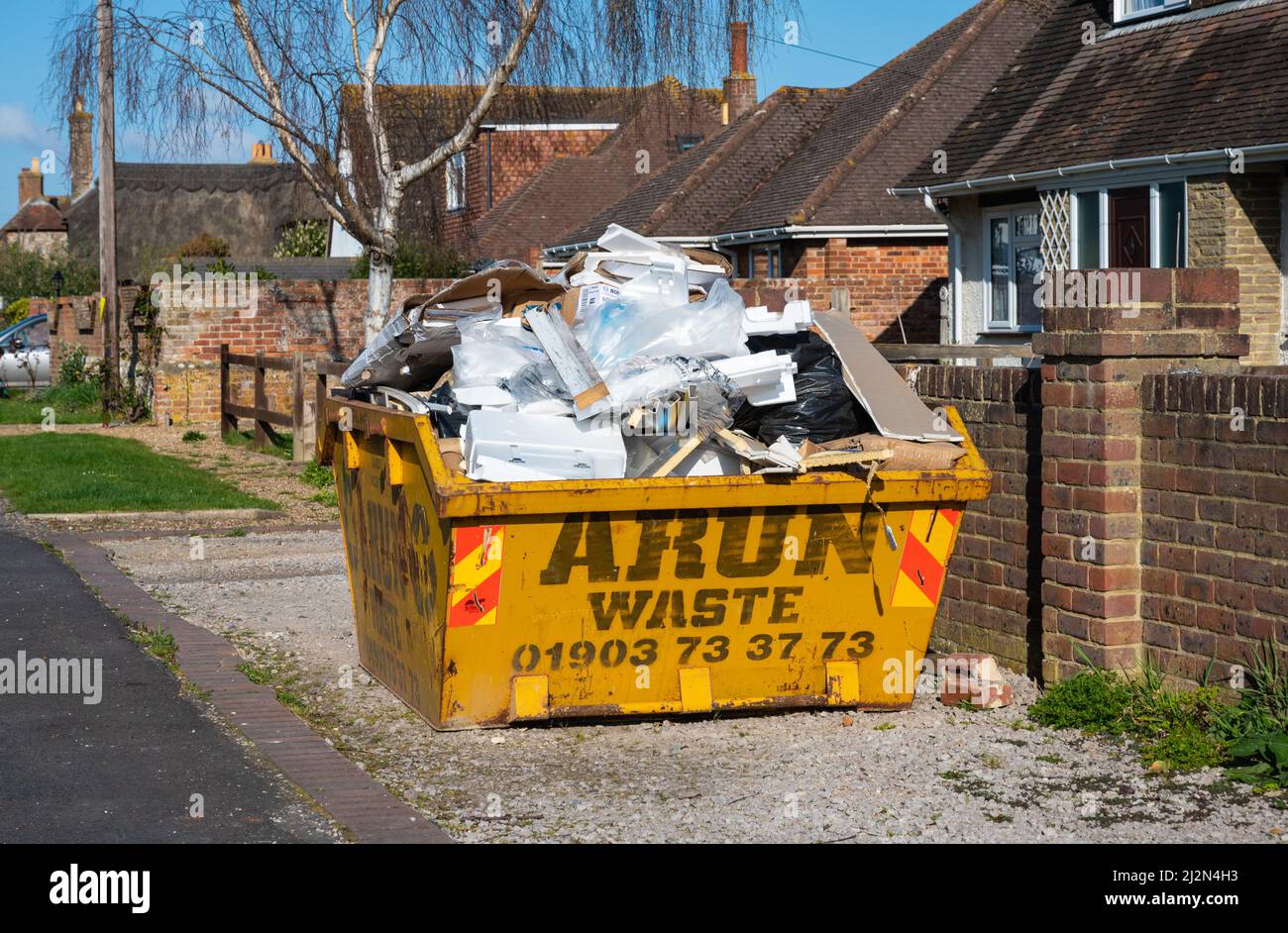 Metallic construction or building skip full up with building waste, in the UK. Stock Photo