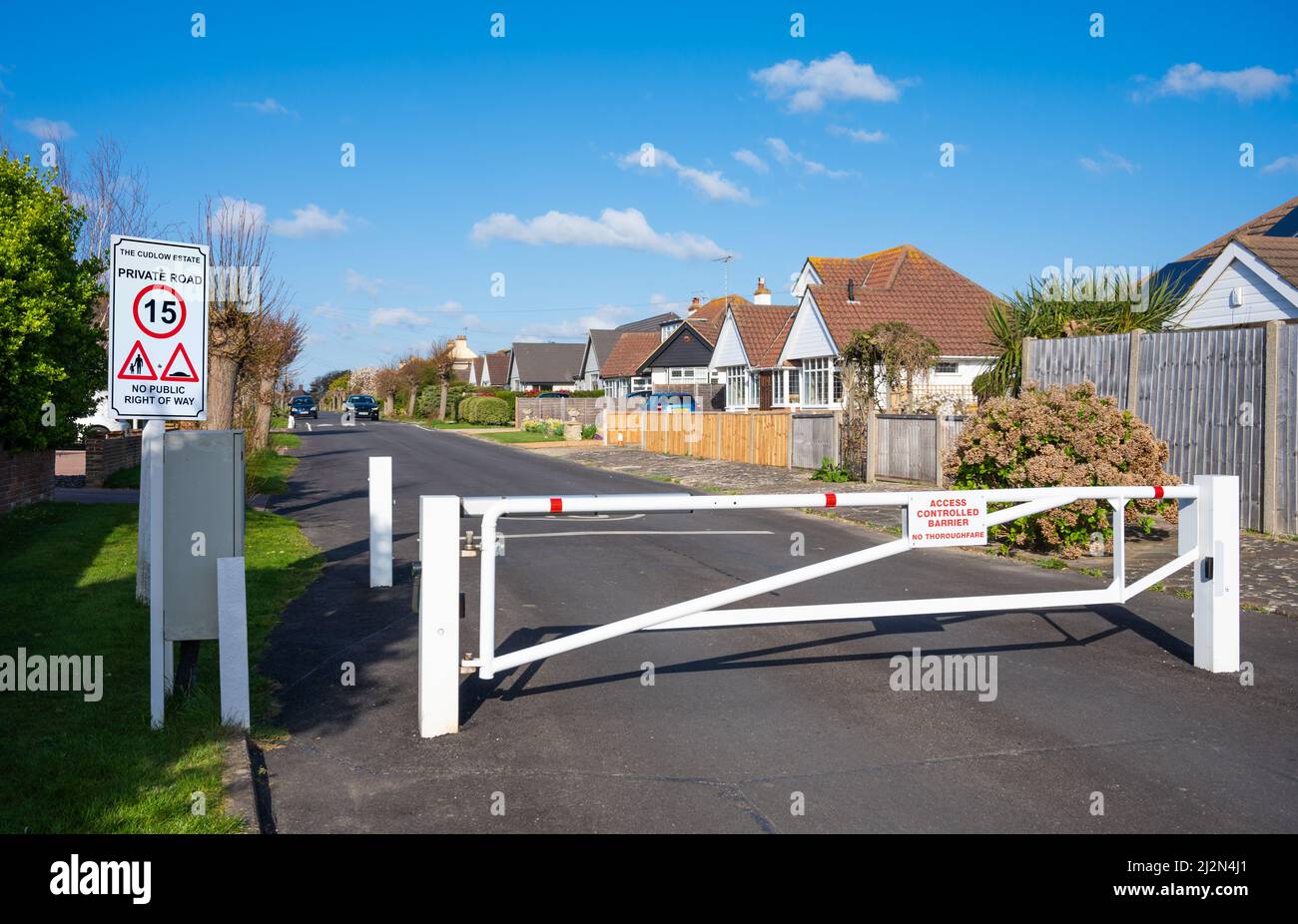 Closed gate at a gated entrance with 15MPH speed limit sign to a private road at Knightscroft Avenue, Rustington, West Sussex, England, UK. Stock Photo