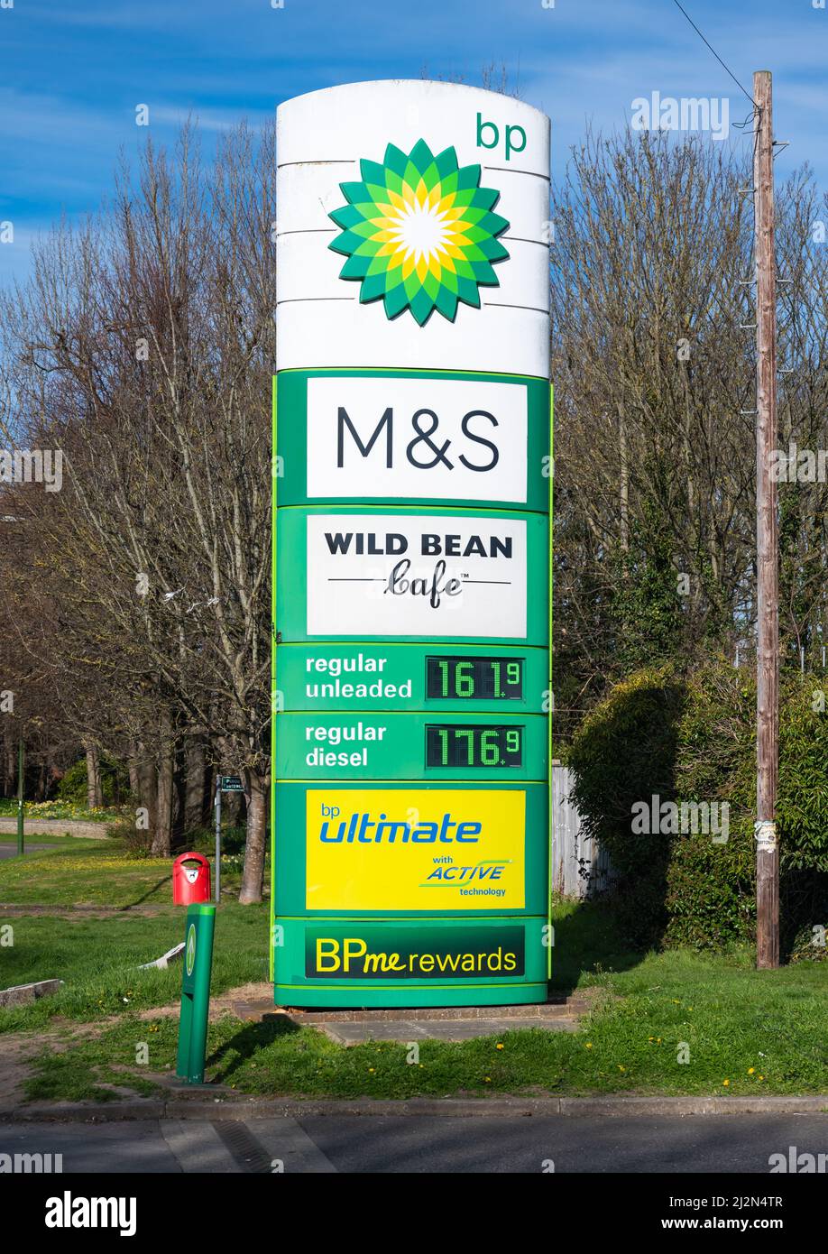 BP forecourt fuel price sign with M&S shop showing high prices of diesel & unleaded petrol in April 2022 as the cost of living rises in England, UK. Stock Photo