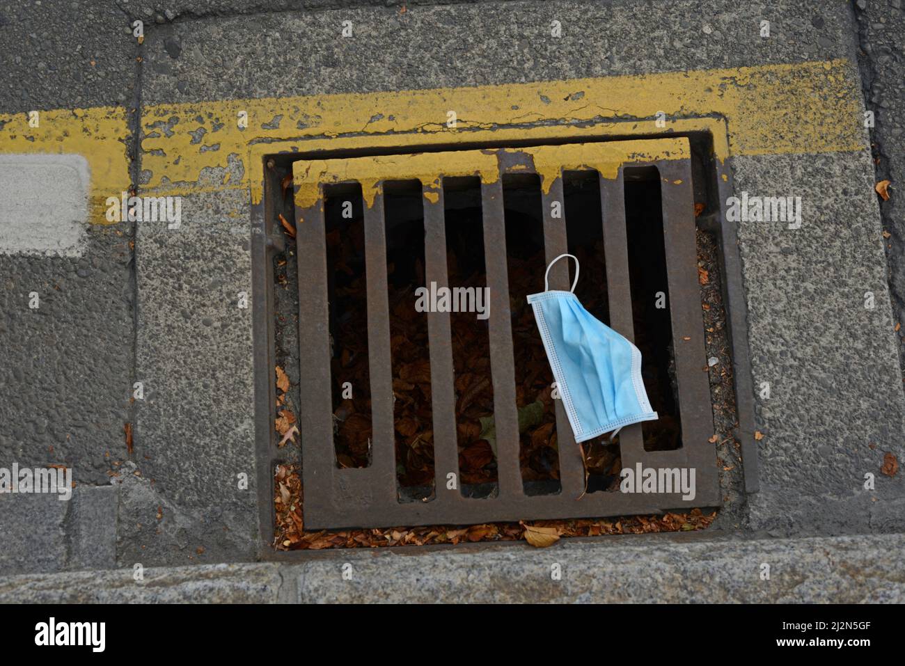 A blue facemask discarded in the street - a sign of the covid pandemic Stock Photo