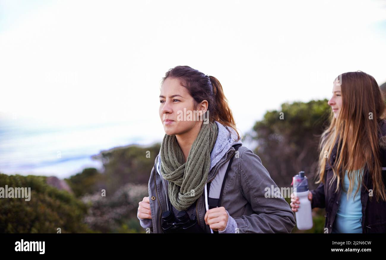 Hiking with a good friend. Shot of two attractive young female hikers ...