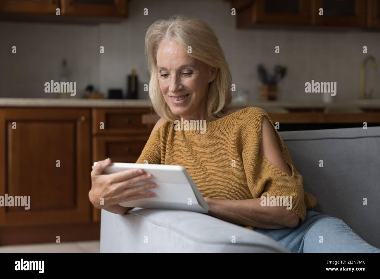 Happy senior tablet user watching movie on gadget Stock Photo Alamy
