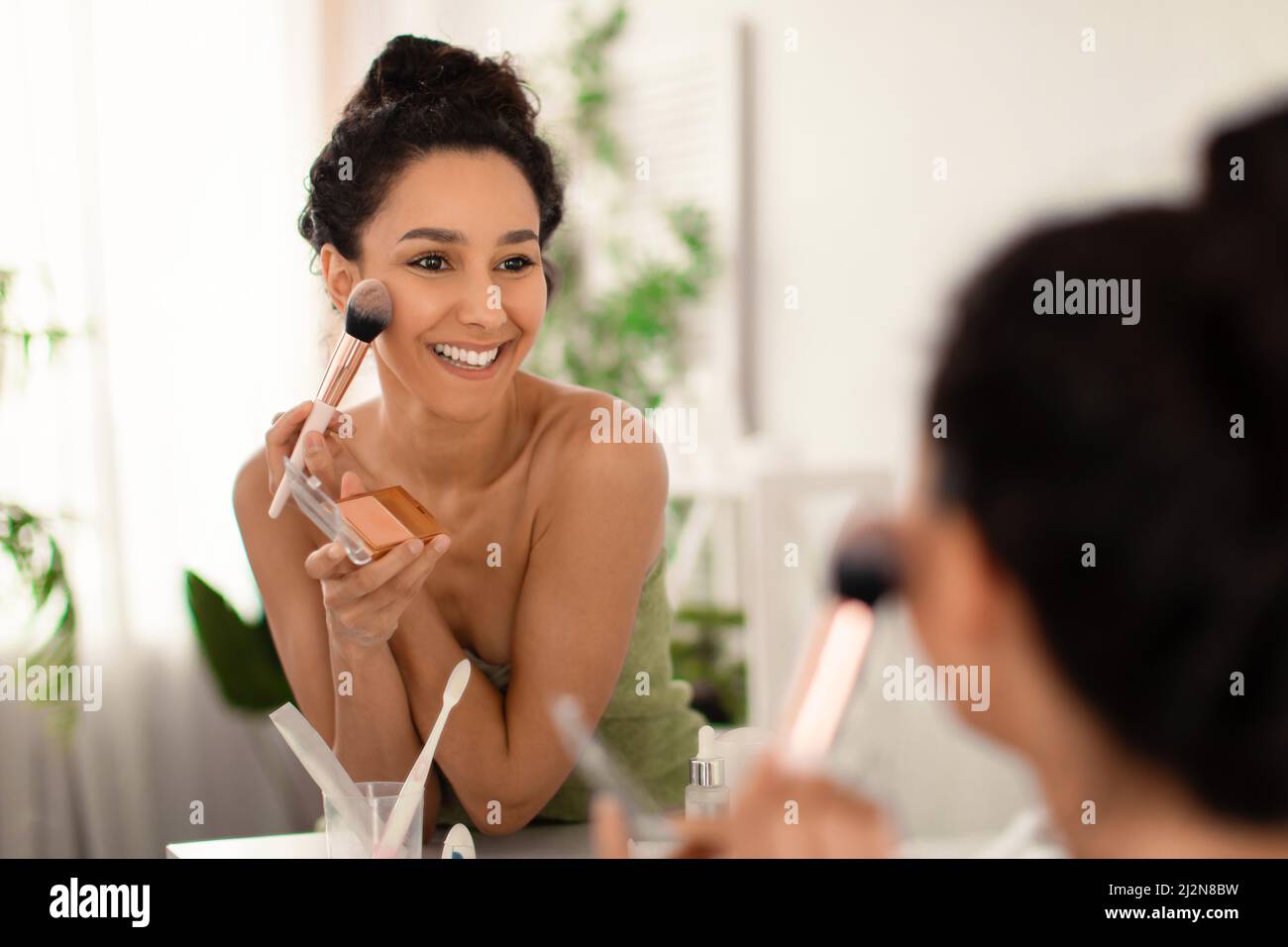 Sexy girl making makeup in bathroom. Woman take care about look. Looking  into a mirror. sexy female booty in luxury bathroom фотография Stock