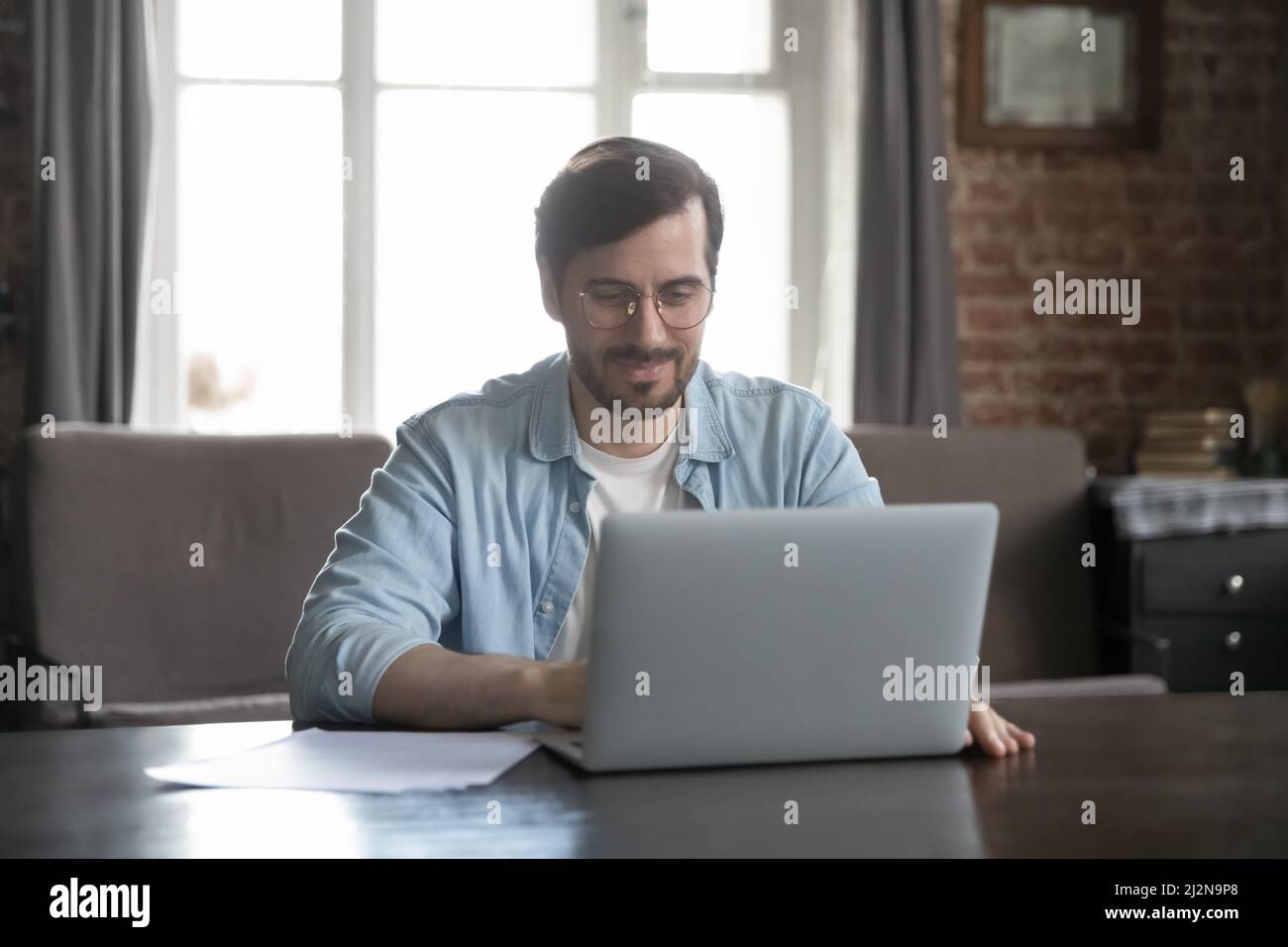 Happy millennial freelance employee man using computer at home office ...