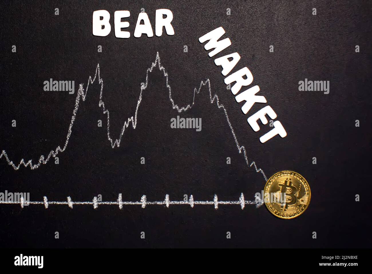 Financial bear market falling concept on blackboard background. Cryptocurrency collapse Stock Photo
