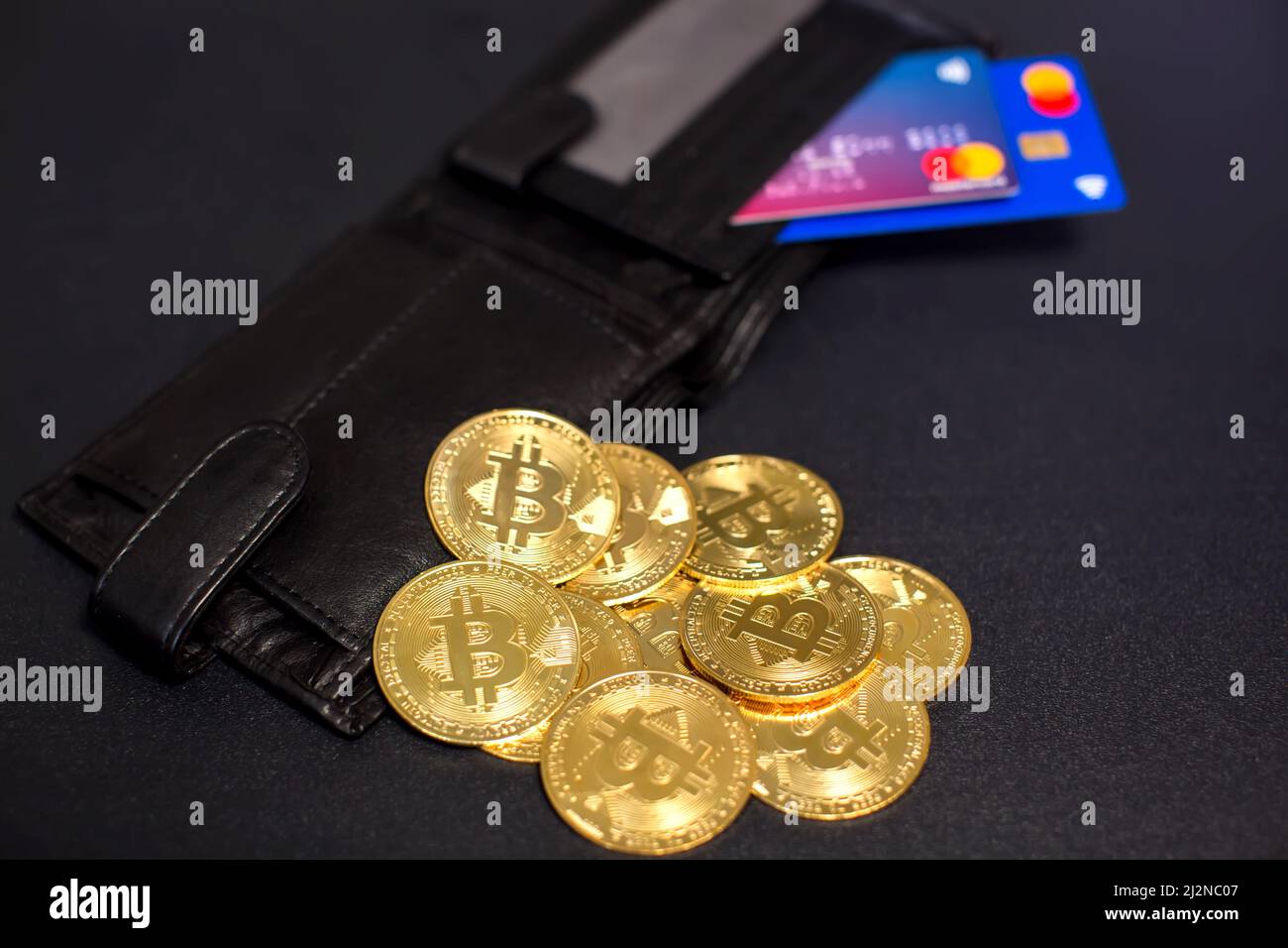 Bitcoin coins and credit cards in a wallet on the blackboard background Stock Photo