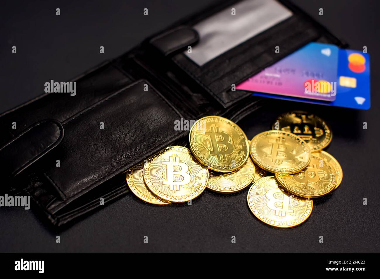 Bitcoin coins and credit cards in a wallet on the blackboard background Stock Photo
