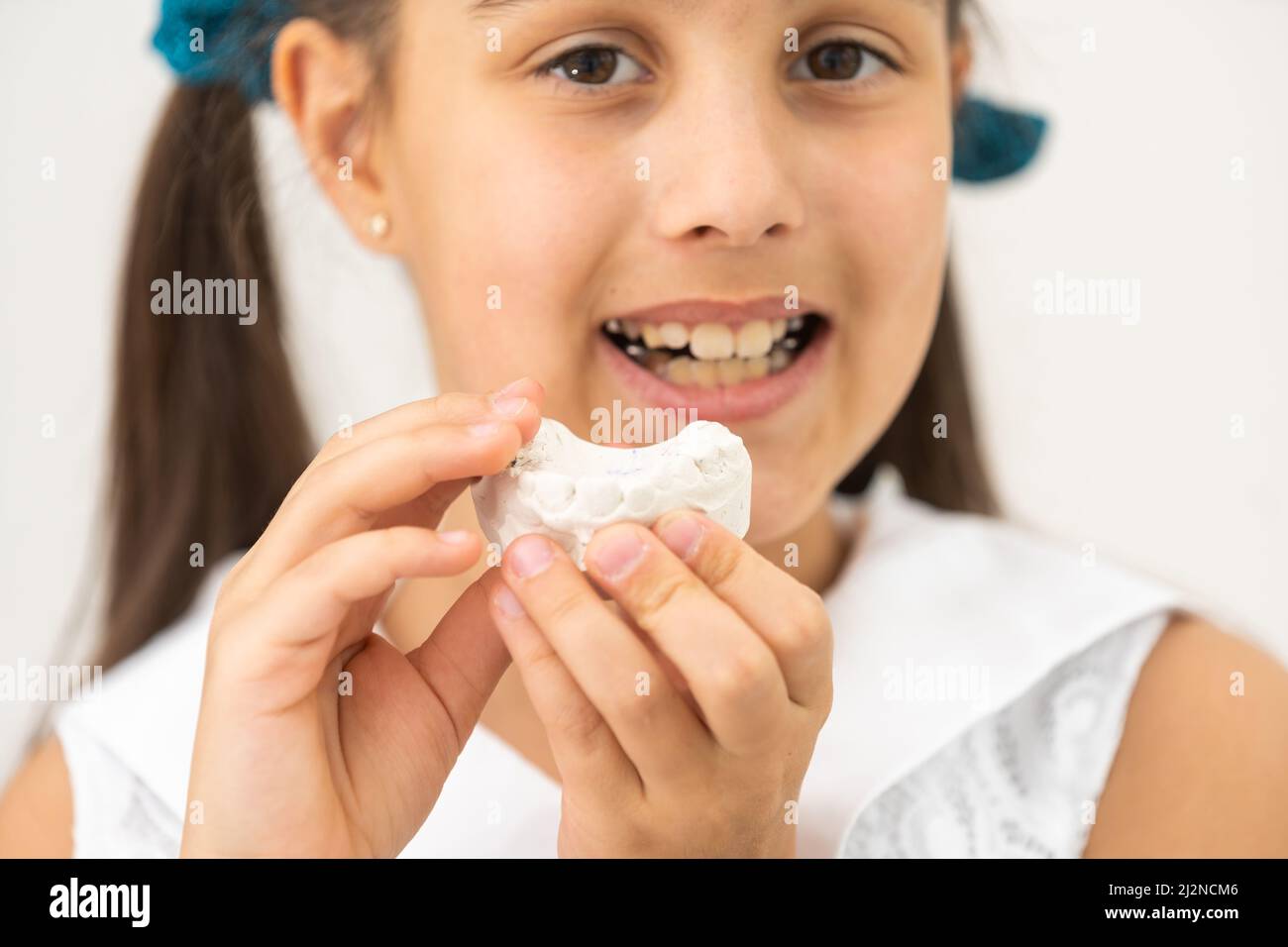 Teenager is holding a dental cast model at the start of orthodontic