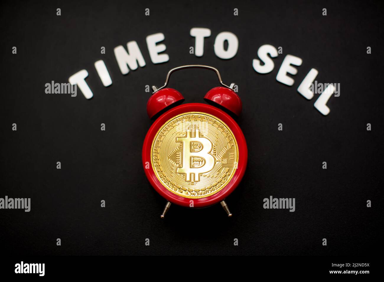 Bitcoin and alarm clock with sign 'Time to sell'. Concept of deadline to invest in bitcoin cryptocurrency. Stock Photo