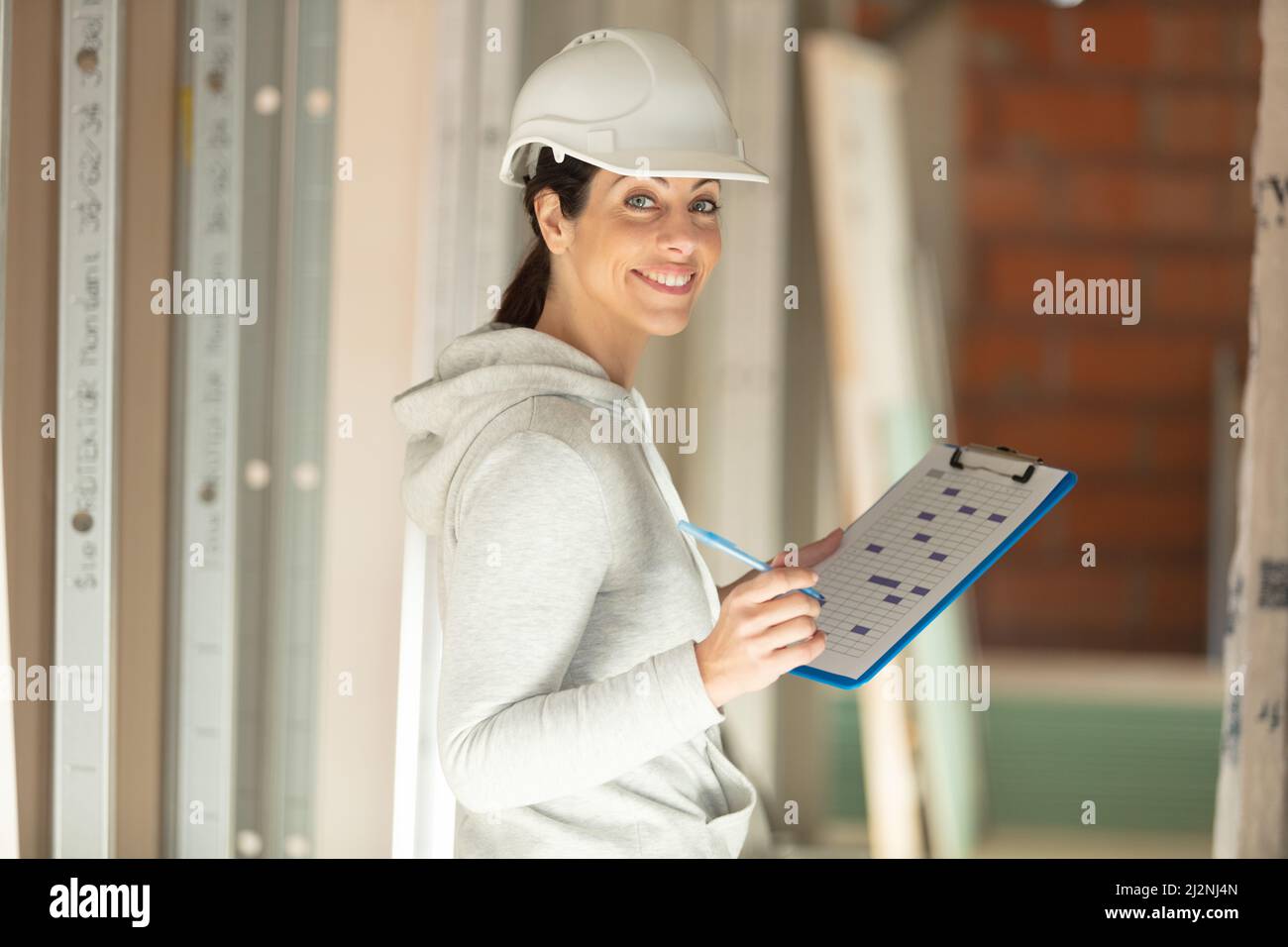 female building inspector holding a clipboard Stock Photo