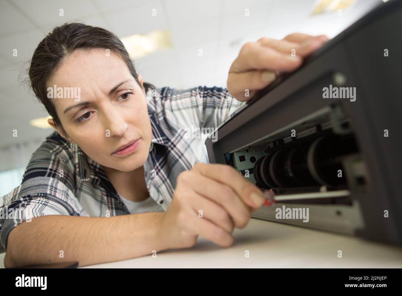 happy female technician fixing printer Stock Photo