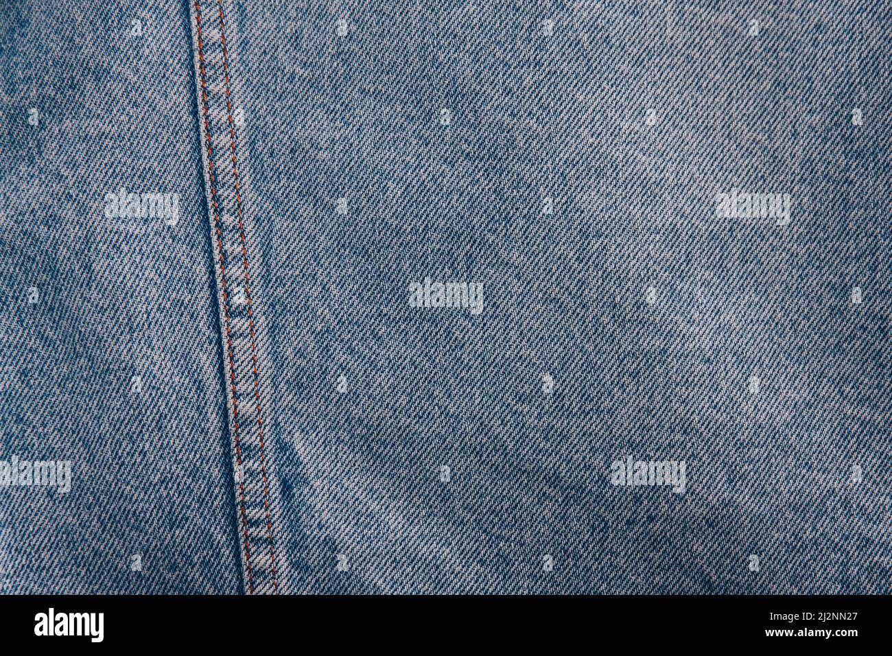 Denim light blue jeans fabric texture stitched with orange threads ...