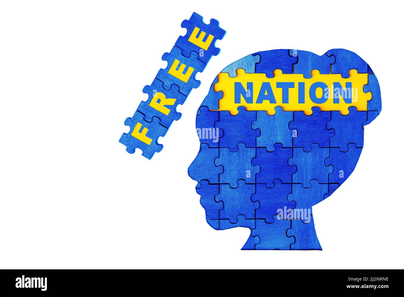 Text FREE NATION inside a female's head profile made of wooden jigsaw puzzle pieces painted blue and yellow. Patriotic concept. Stock Photo
