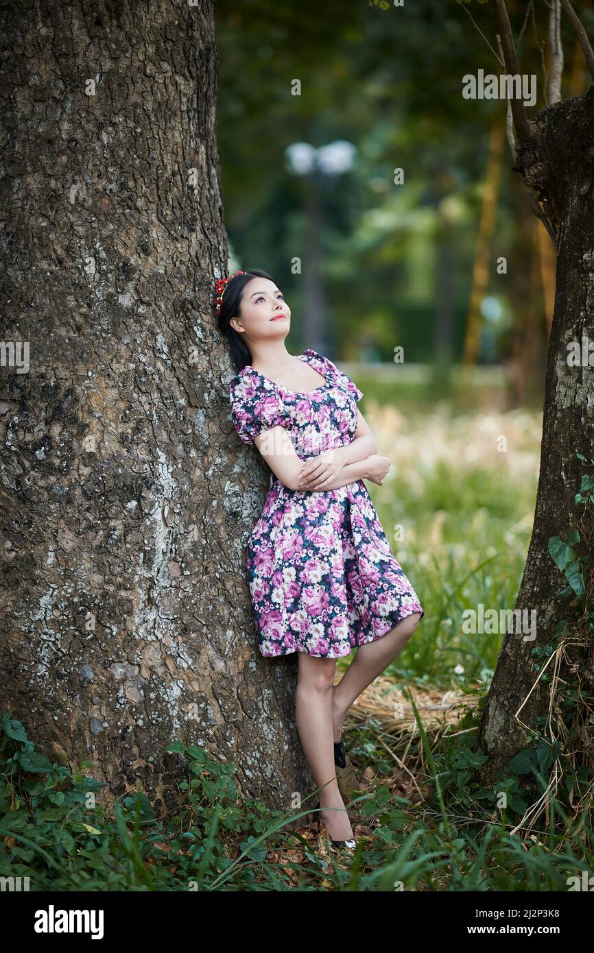 Ho Chi Minh City, Vietnam: Portrait of a beautiful Vietnamese girl walking in the park in a short skirt Stock Photo