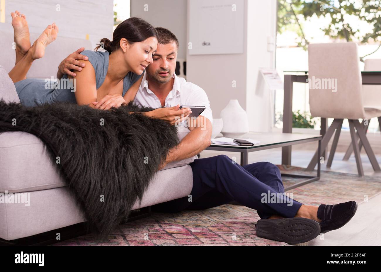 Happy woman with boyfriend using mobile phone Stock Photo