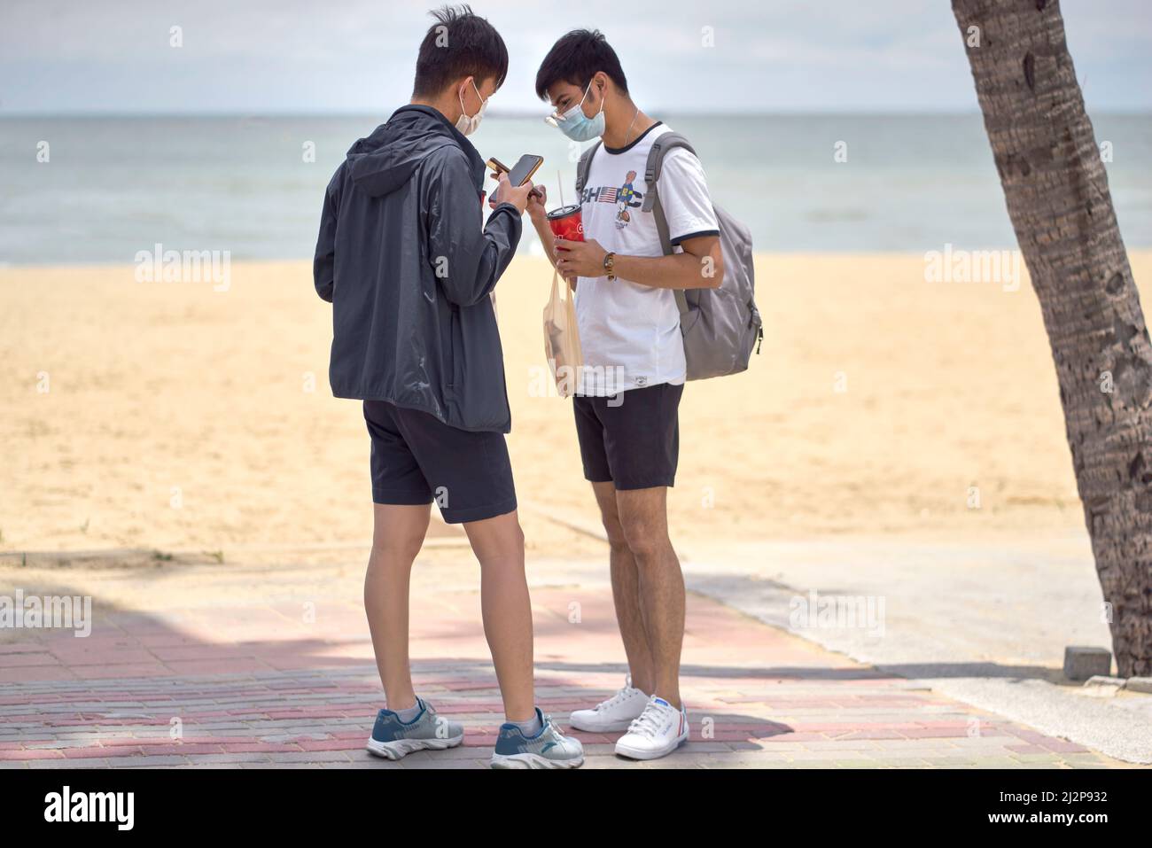 Smartphones people. Two young men checking their smartphones outdoors