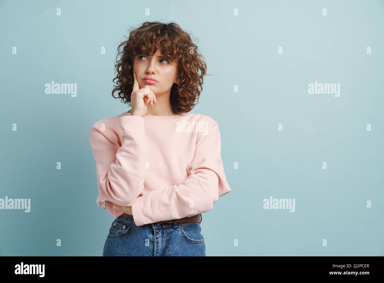 Young ginger serious woman thinking and looking aside isolated over ...