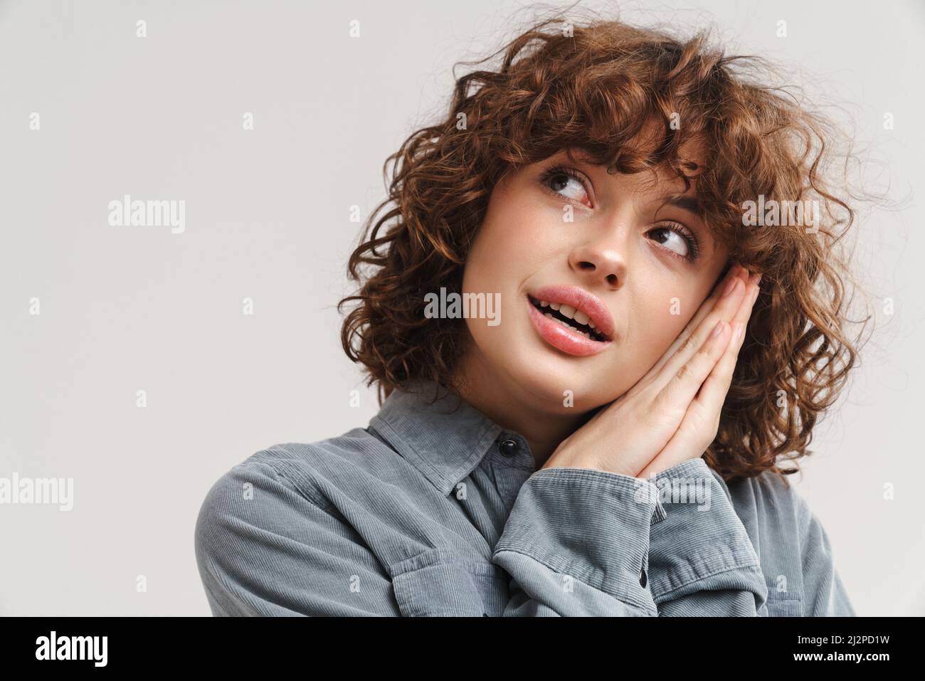 Young ginger woman in shirt posing and looking upward isolated over ...