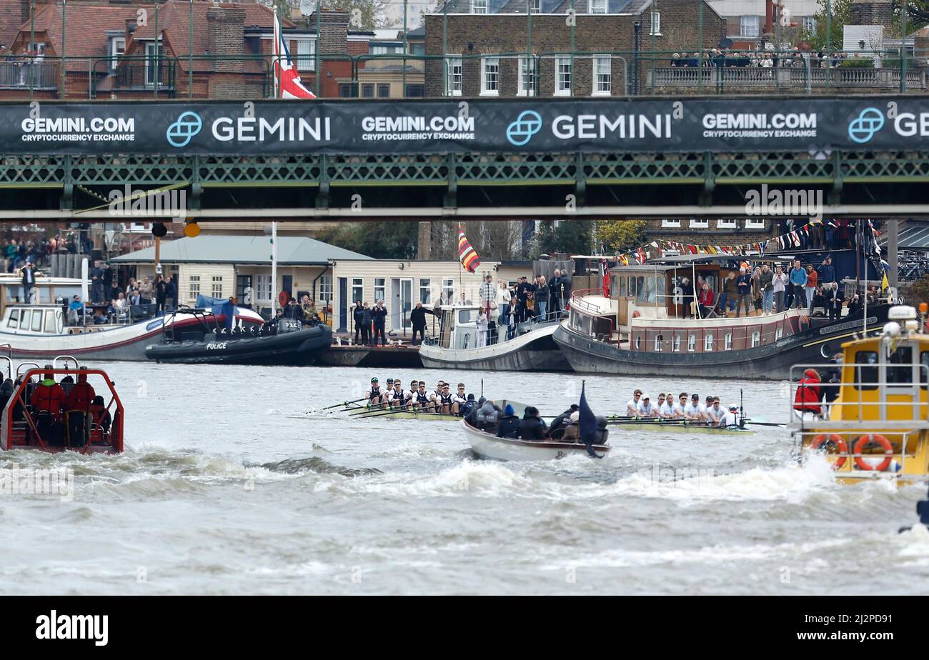 Cambridge and Oxford men's boat teams going past Hammersmith Bridge