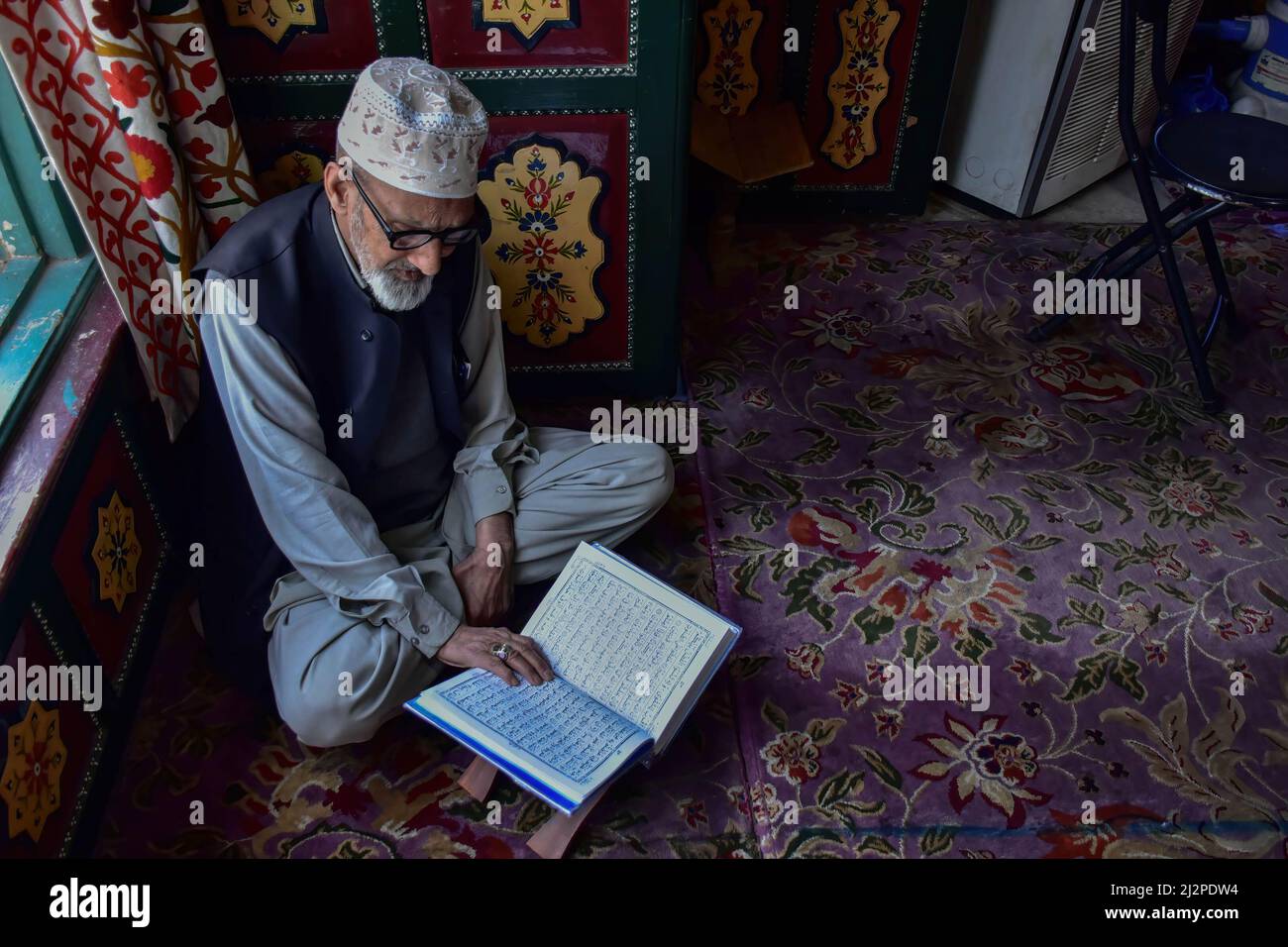 A Kashmiri man recites the Holy Quran inside the shrine of Syed Abdul ...