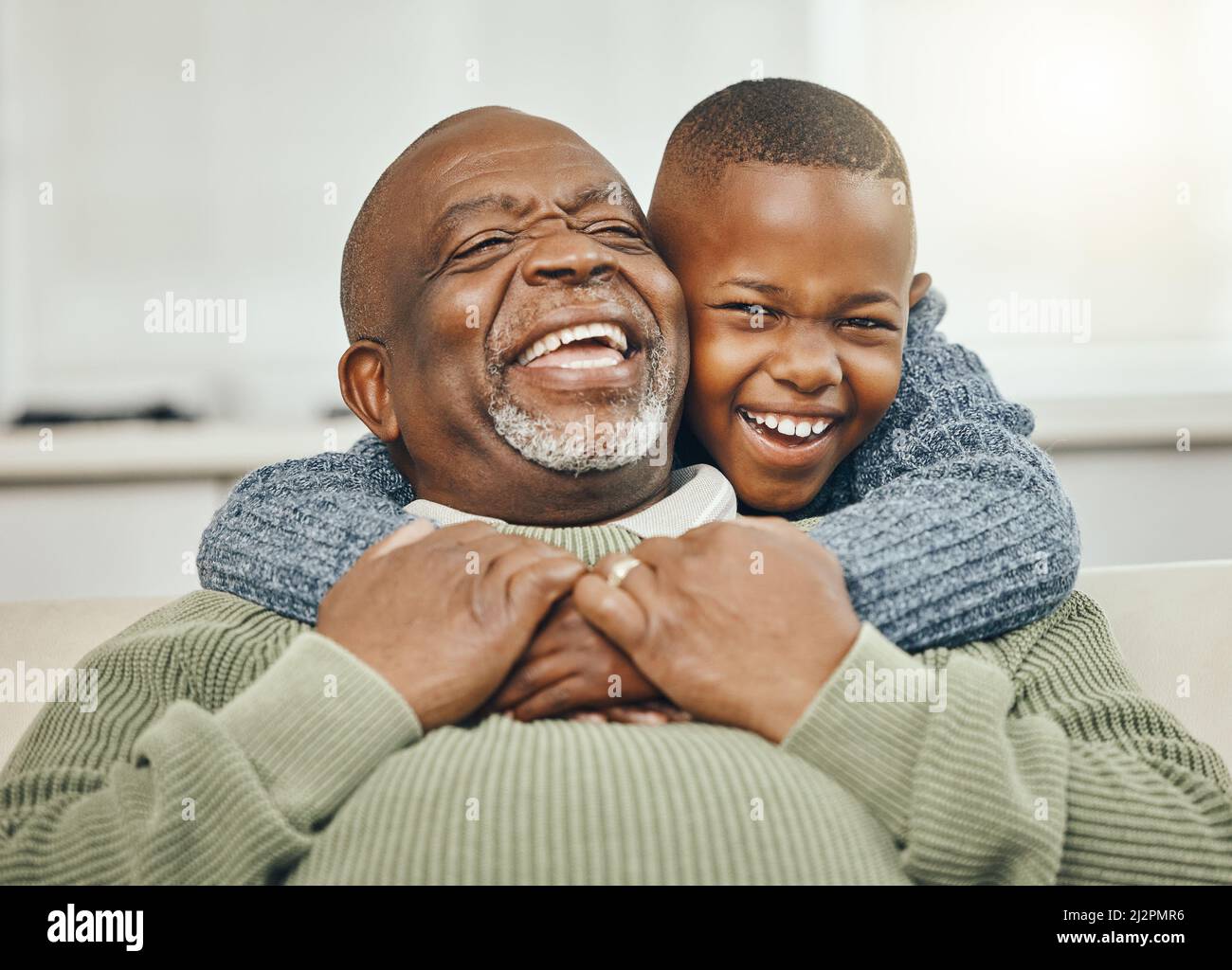 My boy, from my boy. Shot of a grandfather bonding with his young grandson on a sofa at home. Stock Photo