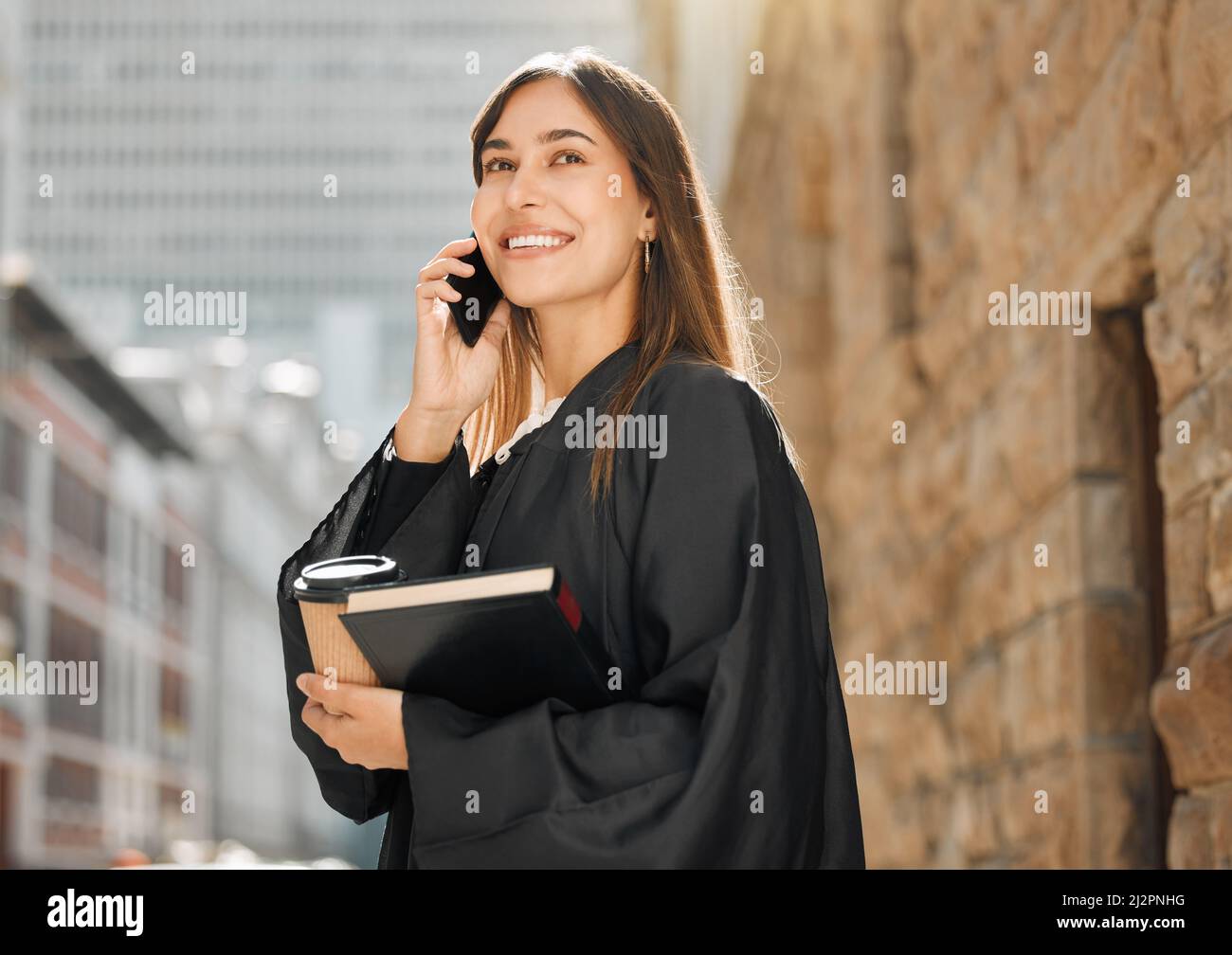 You miss 100 of the shots you dont take. Shot of a young female judge using her smartphone to make a call. Stock Photo