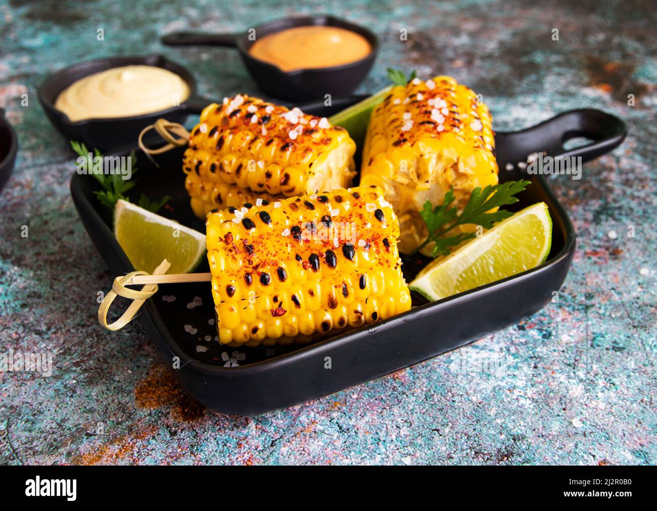 grilled corn with spices lime with white yellow  sauce Stock Photo