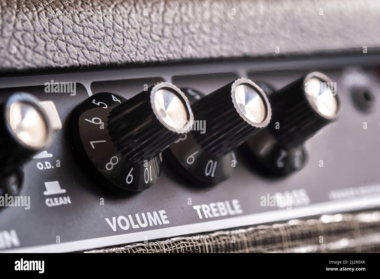 selective focus of the volume, treble and bass control knobs of a guitar amplifier, equalization dials close up, vertical Stock Photo