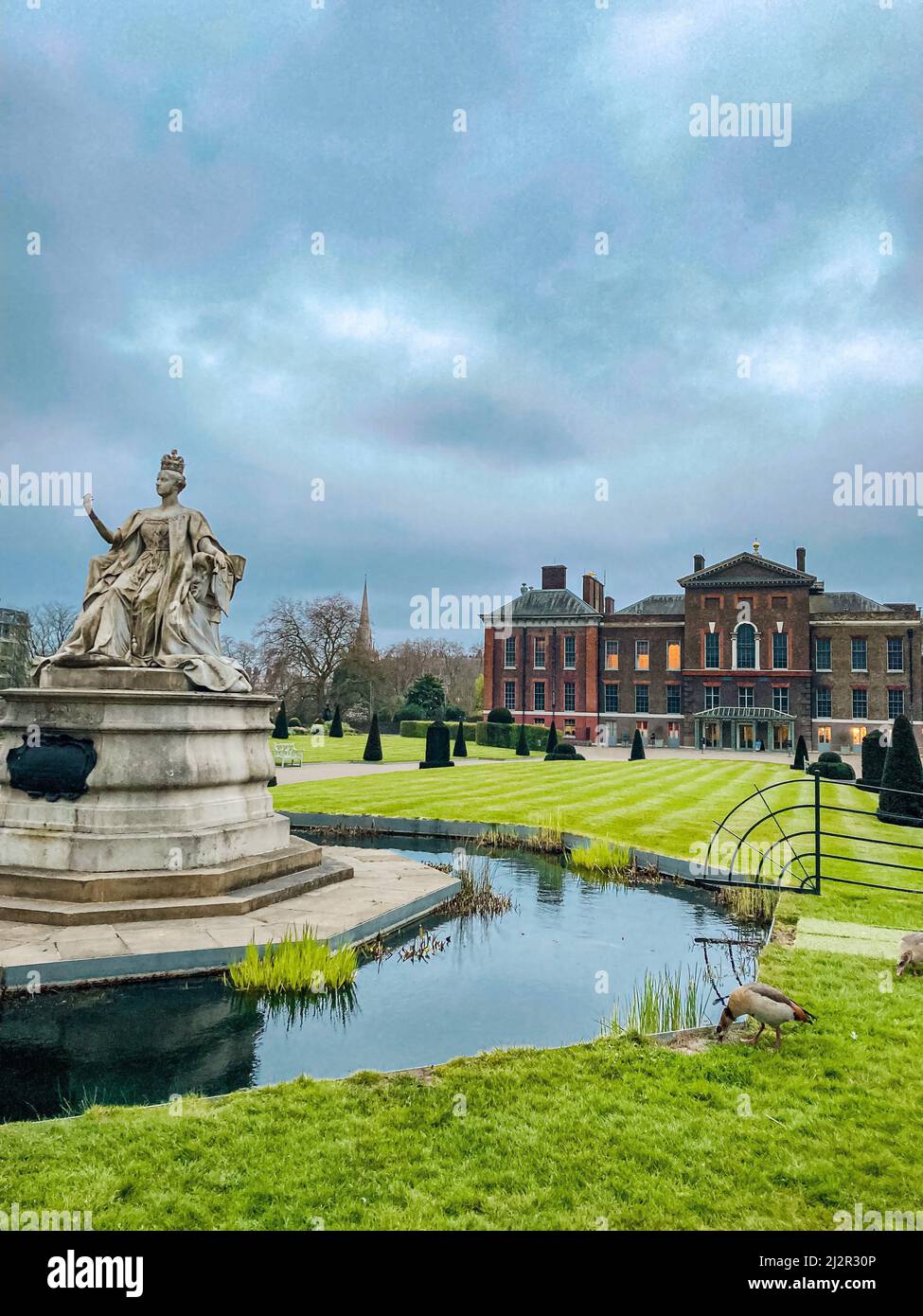 Statue of Queen Victoria in front of Kensington Palace on a cloudy day in Hyde Park, London Stock Photo