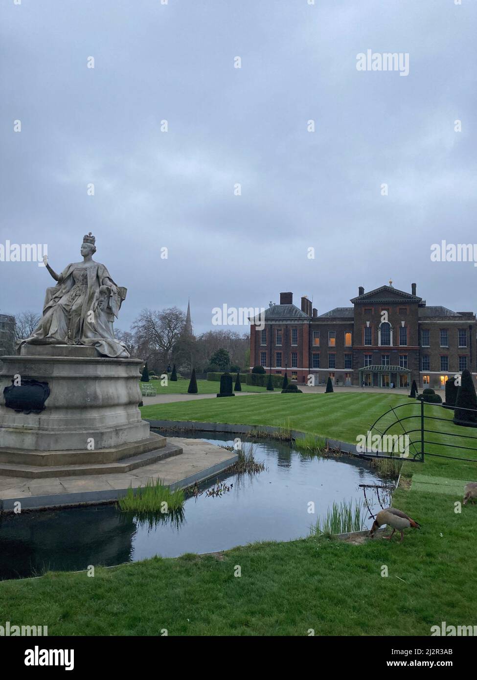 Statue of Queen Victoria in front of Kensington Palace on a cloudy day in Hyde Park, London Stock Photo